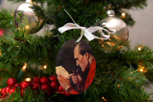 Oval shaped ornament depicts a contemplative Sherlock Holmes writing