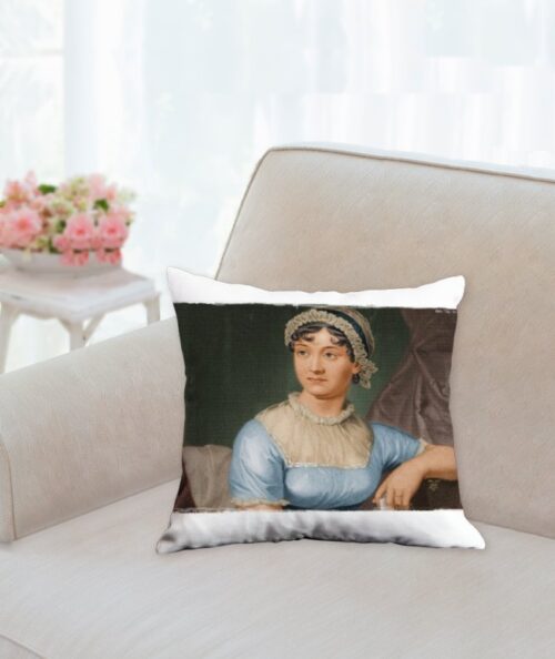 Jane Austen Pillow. Features a portrait of the famous author Jane Austen. The pillow is sitting on the end of a white sofa, with an end table holding a basket of flowers next to the sofa arm.