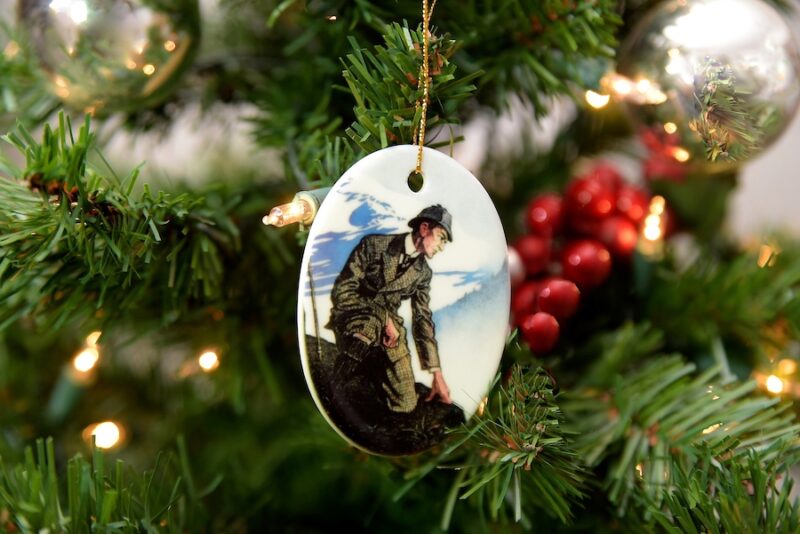 Oval-shaped ornament of Sherlock Holmes atop a mountain