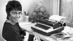 A picture of Rita Mae Brown sitting in front of a typewriter.